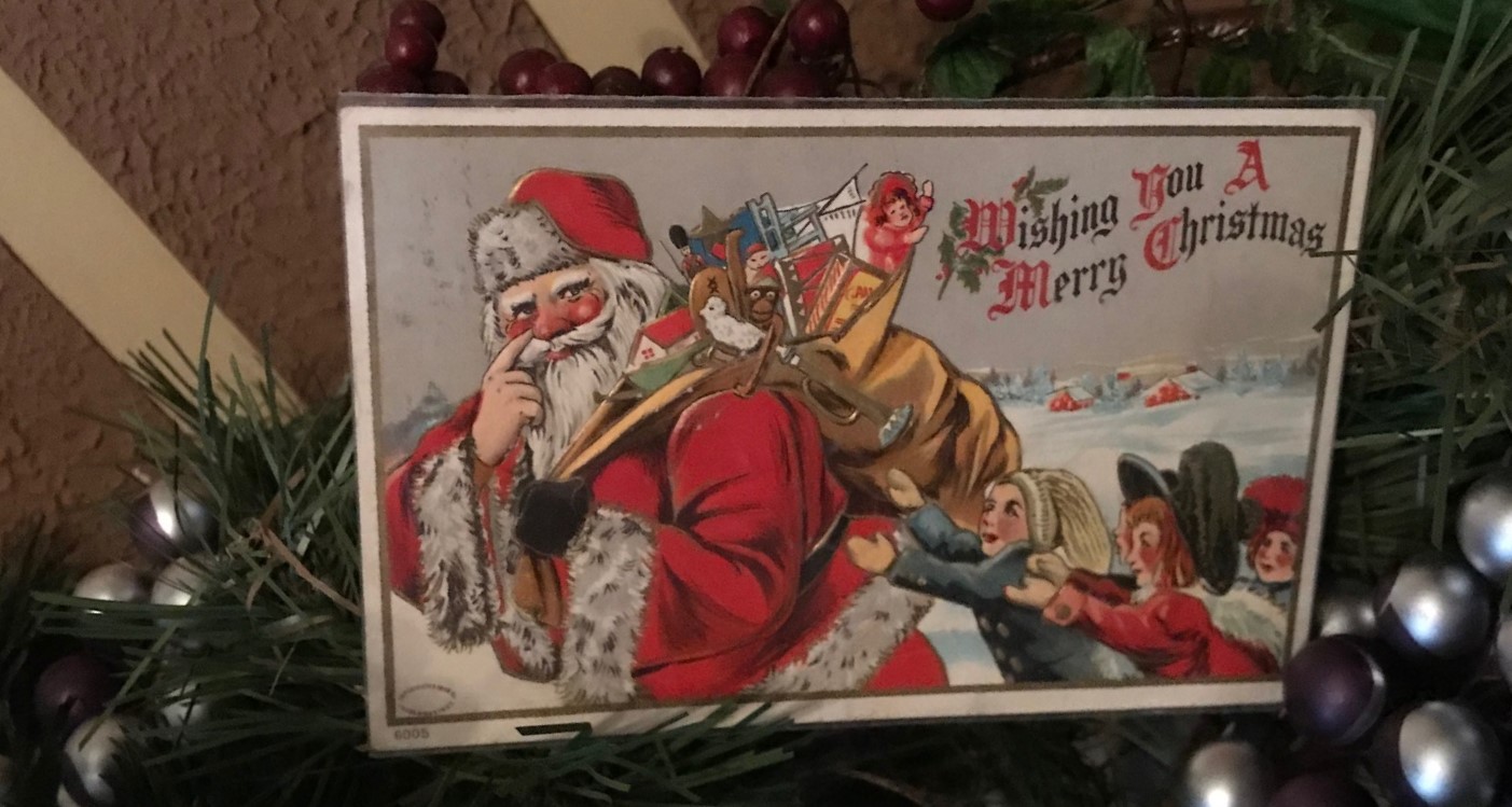 Progressive era postcard featuring Santa Claus with a bag of toys slung over his shoulder to serve as a link to registration page