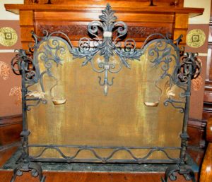Ornate iron and copper fireplace screen.