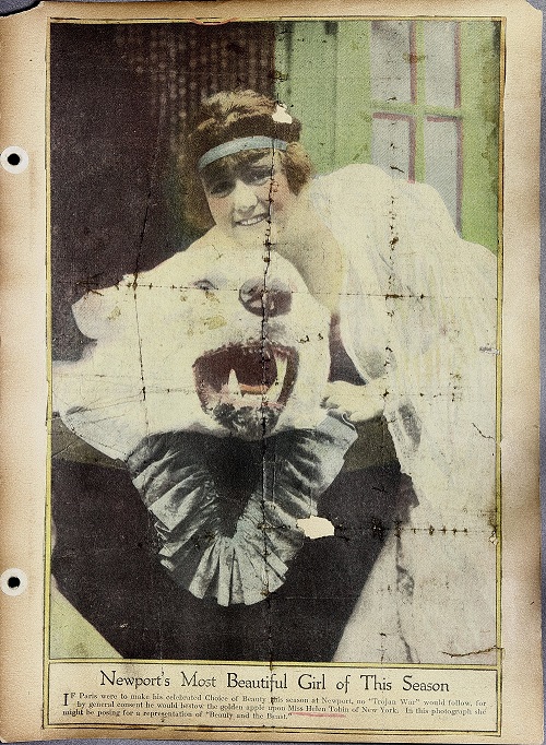 Helen Tobin leans on a polar bear skin. The bear sits on top of a blue silk or satin fabric.