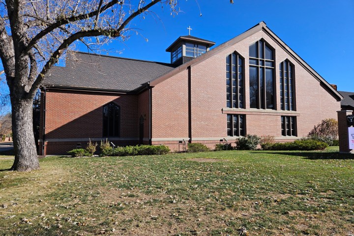a large brick building with grass and trees