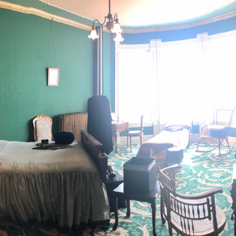 a bedroom with a desk and chair in a room