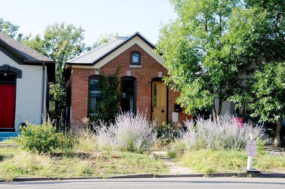 a house that has a sign on the side of a road