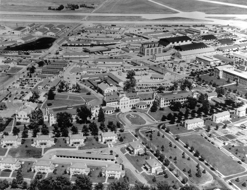 Aerial view of a large military base with buildings, roads, and parked vehicles.