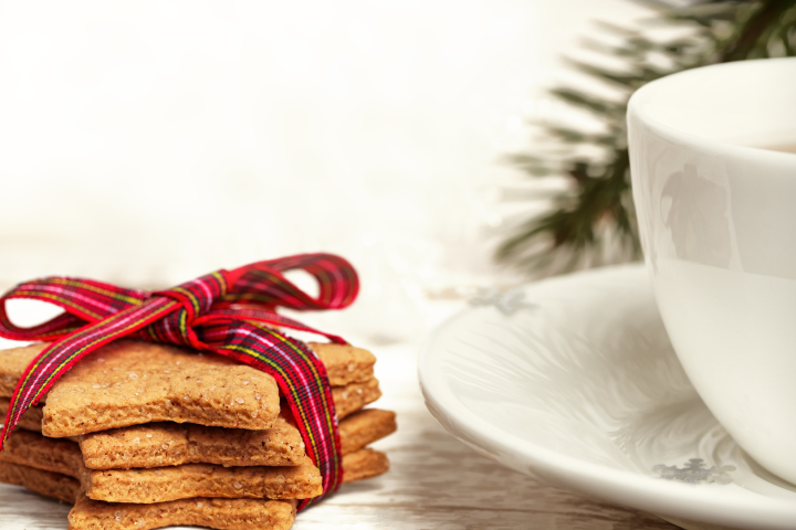 Star-shaped cookies tied with a ribbon beside a cup with a saucer.