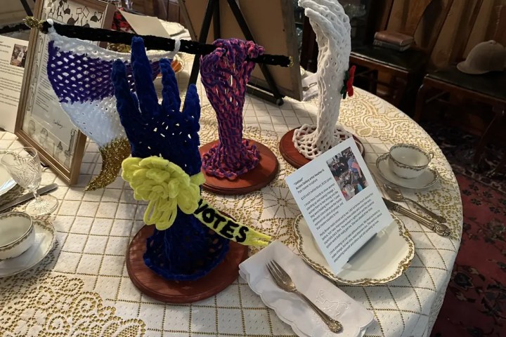 Table with knitted hands, signs, and tea set.