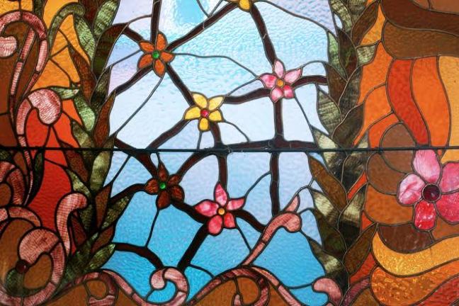 Colorful stained glass with floral patterns and abstract designs.